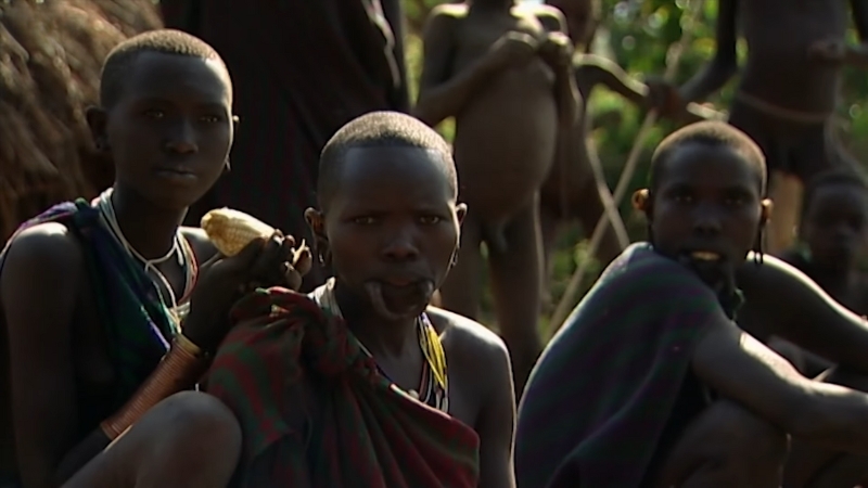 Members of the Surma tribe sit together in a rural village