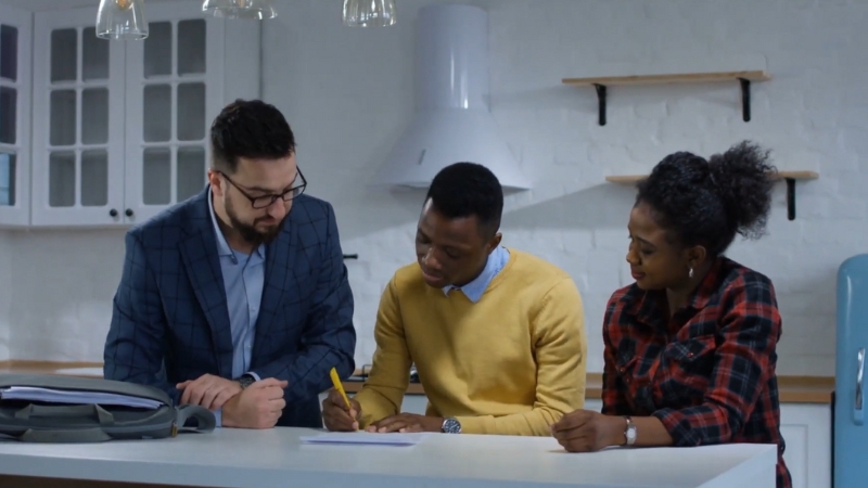 Foreign buyers review real estate in Ethiopia with an agent in a kitchen setting